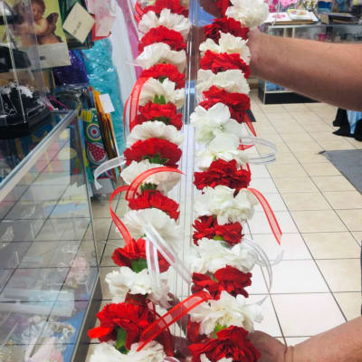 Red and white carnation garlands held on a clear stand