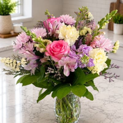 Mixed pink and cream bouquet in a clear glass vase
