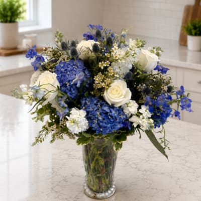 Blue and white flower arrangement in a clear glass vase