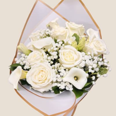 White roses and calla lilies in a wrapped bouquet