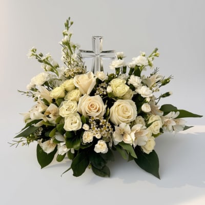 White rose arrangement with a clear cross centerpiece