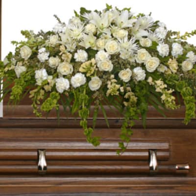 White floral casket spray with roses and lilies