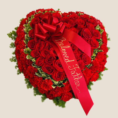Heart-shaped red rose arrangement with a red ribbon