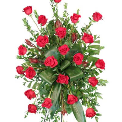 Tall arrangement of red roses with greenery and broad leaves