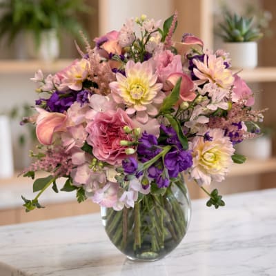 Pink and purple mixed flower bouquet in a clear glass vase