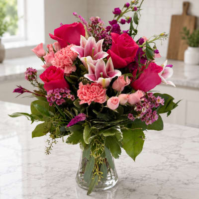 Pink and magenta mixed flower bouquet in a clear glass vase