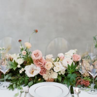 Low wedding centerpiece with blush and white flowers on a table