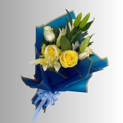 Bouquet of yellow roses and white lilies wrapped in blue paper