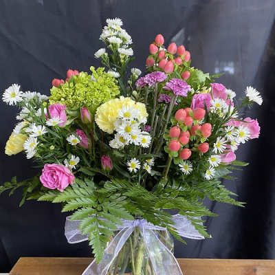 Mixed bouquet in a glass vase with pink, white, and yellow flowers