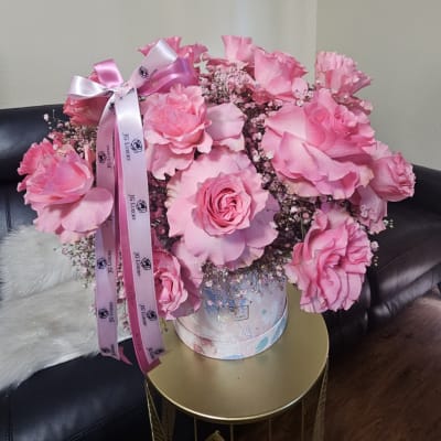 Pink rose bouquet in a round hatbox with satin ribbon