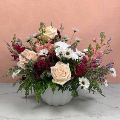Mixed bouquet in a white pumpkin vase with cream roses and white daisies