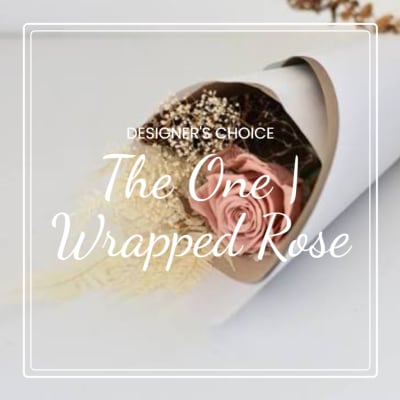Single pink rose wrapped in paper with baby's breath