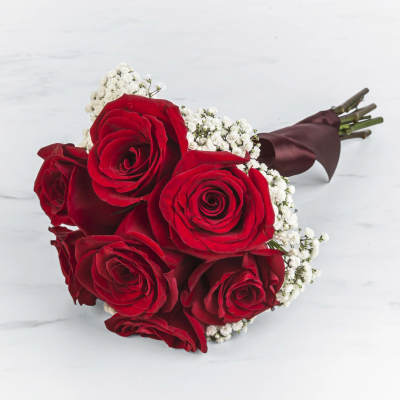 Hand-tied bouquet of red roses with white filler flowers and wrapped stems