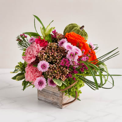 Colorful mixed flower arrangement in a rustic wooden box