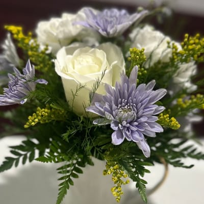 White roses and lavender daisies in a white vase