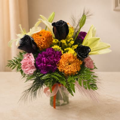 Colorful bouquet with lilies, roses, and carnations in a glass vase