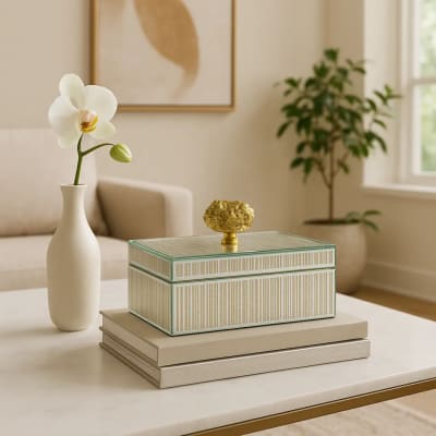 White orchid in a vase beside a decorative box on a table