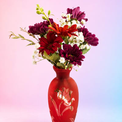 Mixed red and purple flowers arranged in a red vase