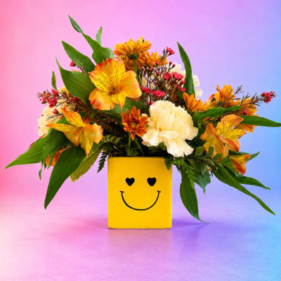 Yellow vase with a mixed bouquet of orange, white, and red flowers