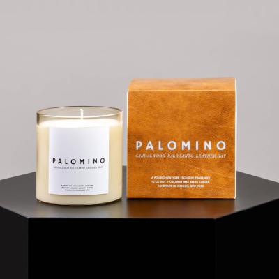 Scented candle in a glass jar beside its orange box