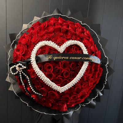 Round bouquet of red roses with a pearl heart and black ribbon