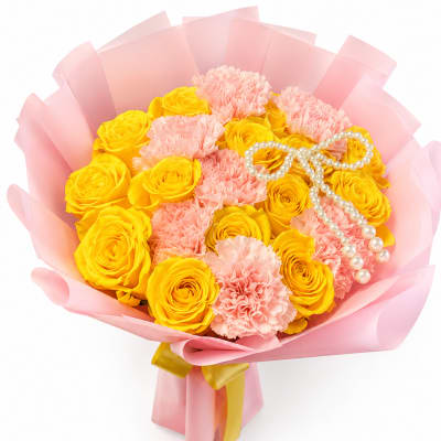Yellow roses and pink carnations wrapped in pink paper with pearl accents
