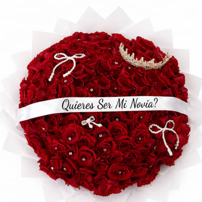 Heart-shaped bouquet of red roses with a white ribbon and jeweled accents