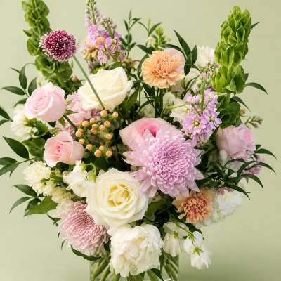 Pastel mixed flower arrangement in a clear glass vase