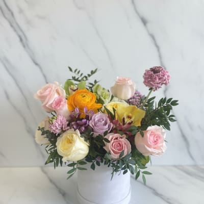 Mixed pastel flower arrangement in a white hat box
