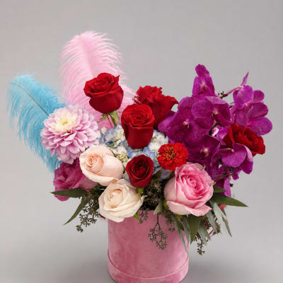 Pink and red rose arrangement with orchids in a pink hat box