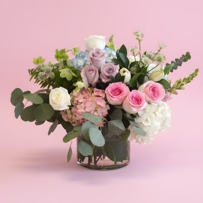 Pink and white roses with hydrangeas in a glass vase
