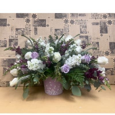Lavender and white floral arrangement in a pink vase