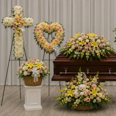 Funeral casket surrounded by pastel floral sprays and wreaths