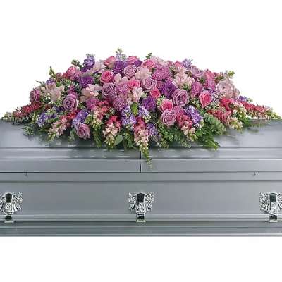Large pink and purple floral casket spray on a gray casket