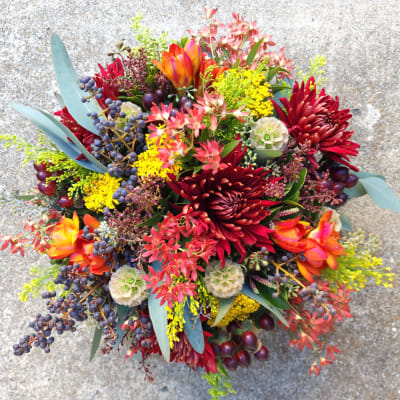 Colorful bouquet with red chrysanthemums, orange tulips, and yellow filler flowers