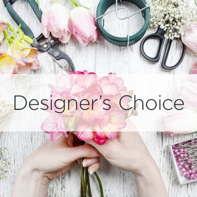 Hands holding a pink flower bouquet with floral tools around it