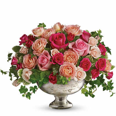Pink and peach roses arranged in a silver pedestal vase