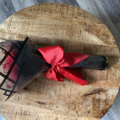 Wrapped bouquet tied with a red satin ribbon