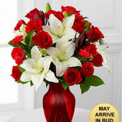 Red roses and white lilies arranged in a red vase