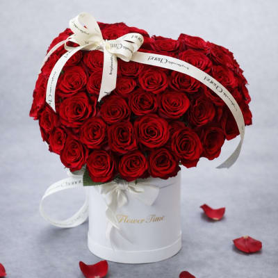 Large bouquet of red roses in a white hatbox with ribbon