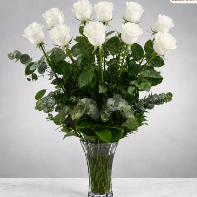Tall bouquet of white roses in a clear glass vase