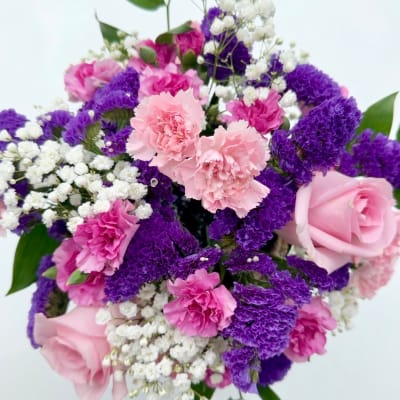 Bouquet of pink roses, carnations, and purple filler flowers