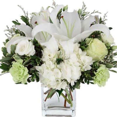 White lilies and roses arranged in a clear glass vase