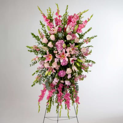 Tall pink floral standing arrangement on a metal easel