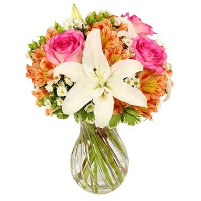Pink roses and white lilies in a clear glass vase
