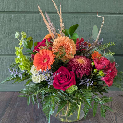 Mixed bouquet in a clear glass vase with roses, gerbera daisies, and chrysanthemums