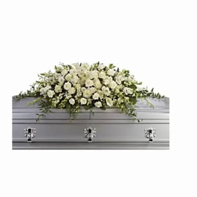 White floral casket spray with roses and other blooms on a silver casket