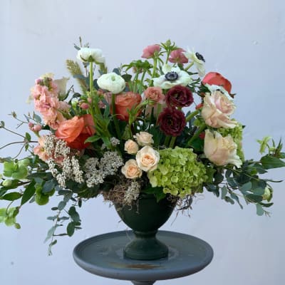 Mixed bouquet in a dark vase with pink, white, coral, and burgundy blooms