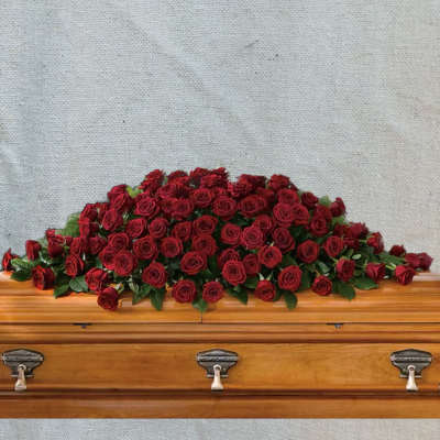 Red rose casket spray on a wooden coffin