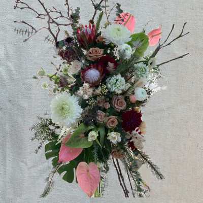 Tall floral arrangement with pink, white, and burgundy blooms